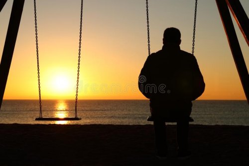 man-alone-looking-sunset-beach-back-view-backlighting-silhouette-sitting-swing-140368332.jpg